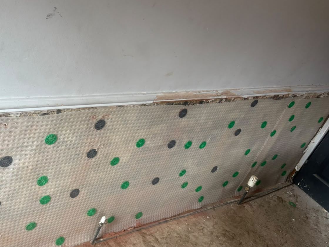 Meshed damp proof membrane fixed to a treated wall in an HMO property