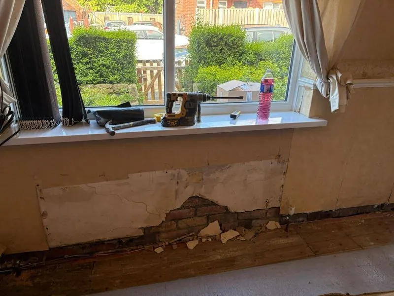 Damp and blown plaster below a window sill where condensation collects