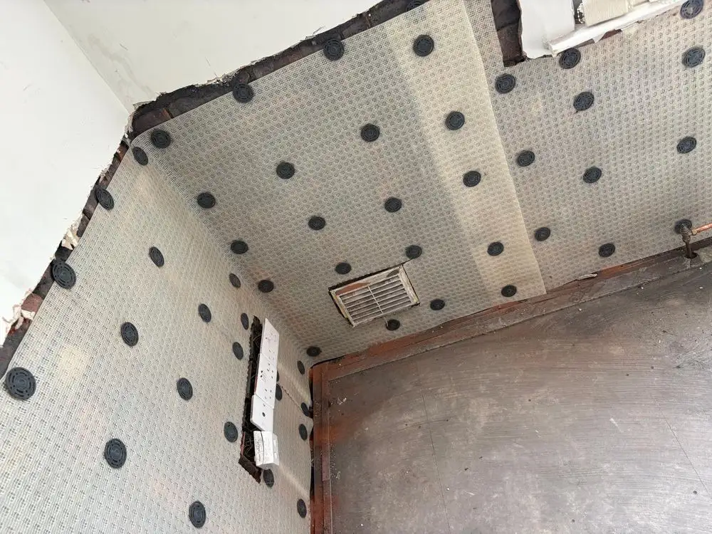 Damp proof membrane fixed around a wall vent and sockets in the corner of a room