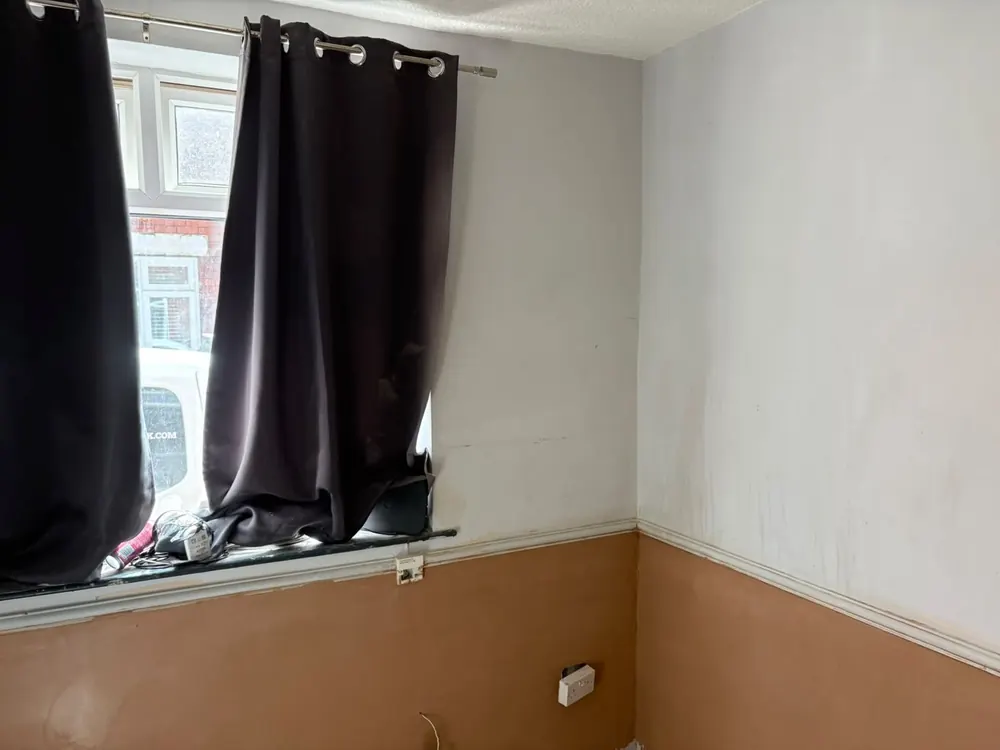 A finished room with the lower walls replastered smooth and curtains at the window