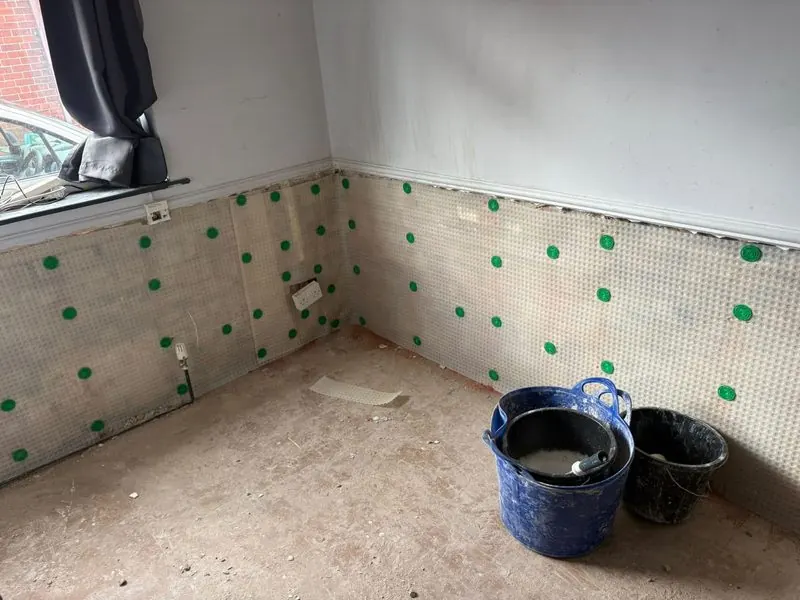 Meshed damp proof membrane fixed across two walls of a room during a damp treatment