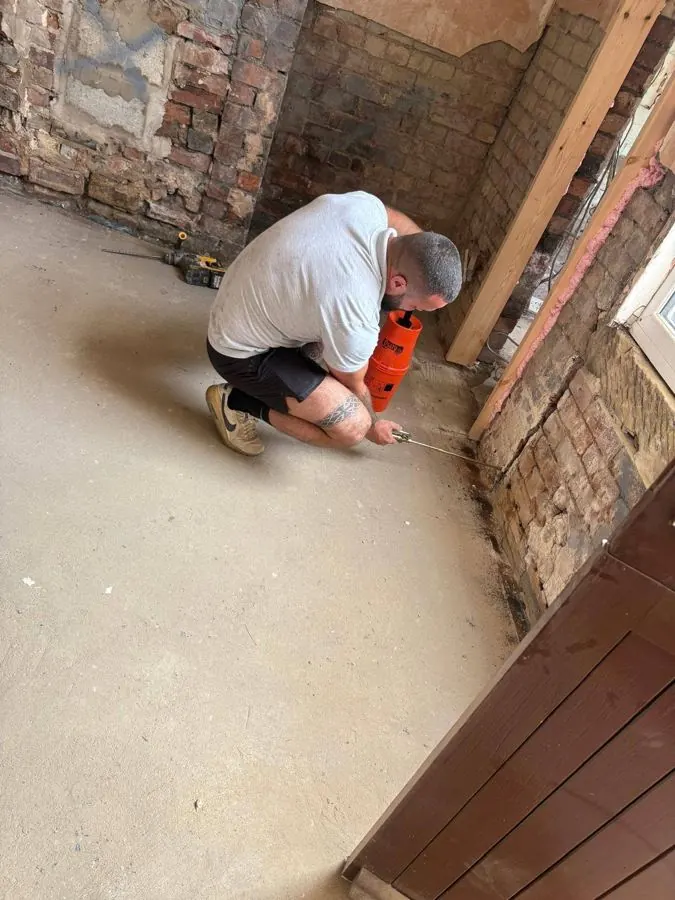 E&H technician preparing a wall for damp proof course injection