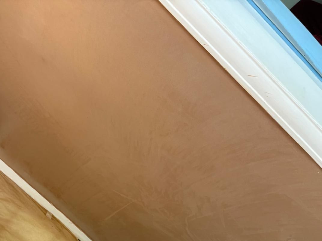 A stairwell wall freshly skimmed to a smooth finish over previous artex