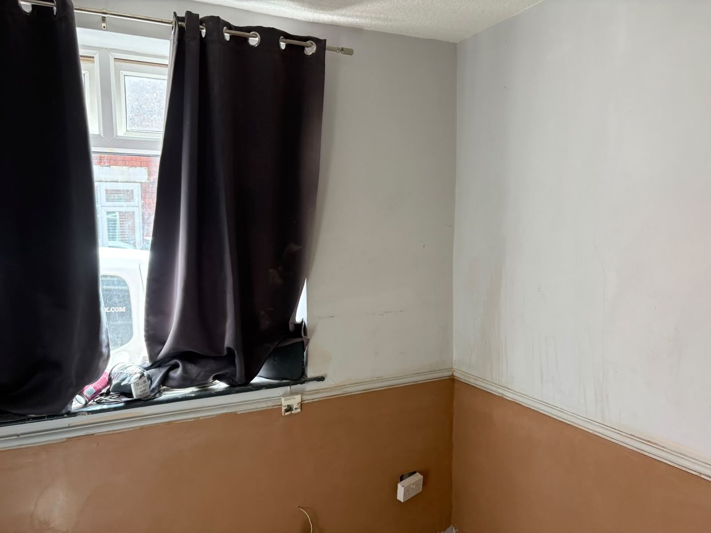 A finished room with the lower walls replastered smooth and curtains at the window