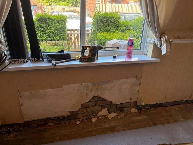 Damp and blown plaster below a window sill where condensation collects